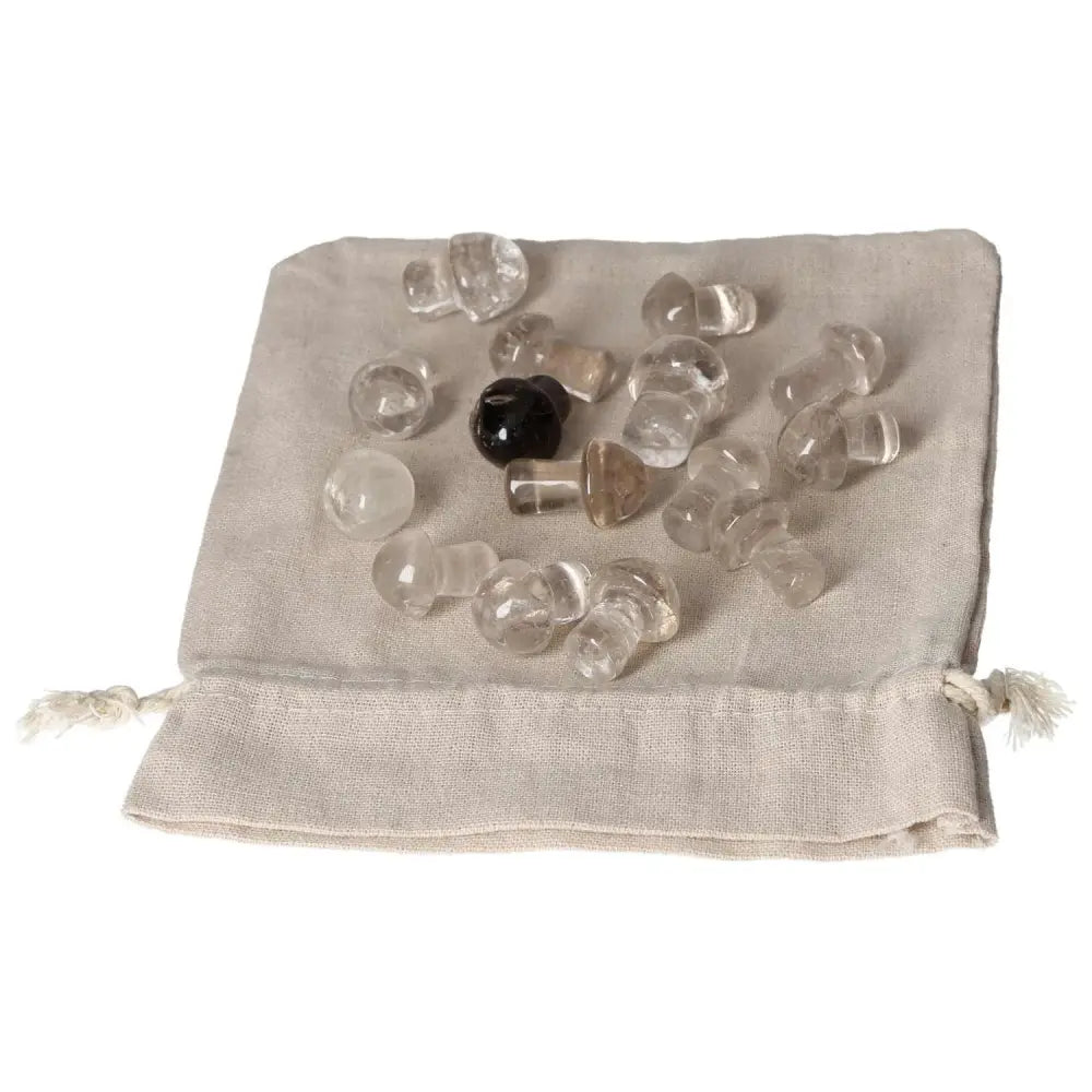 Pile of smoky quartz small mushroom stones on a beige drawstring bag