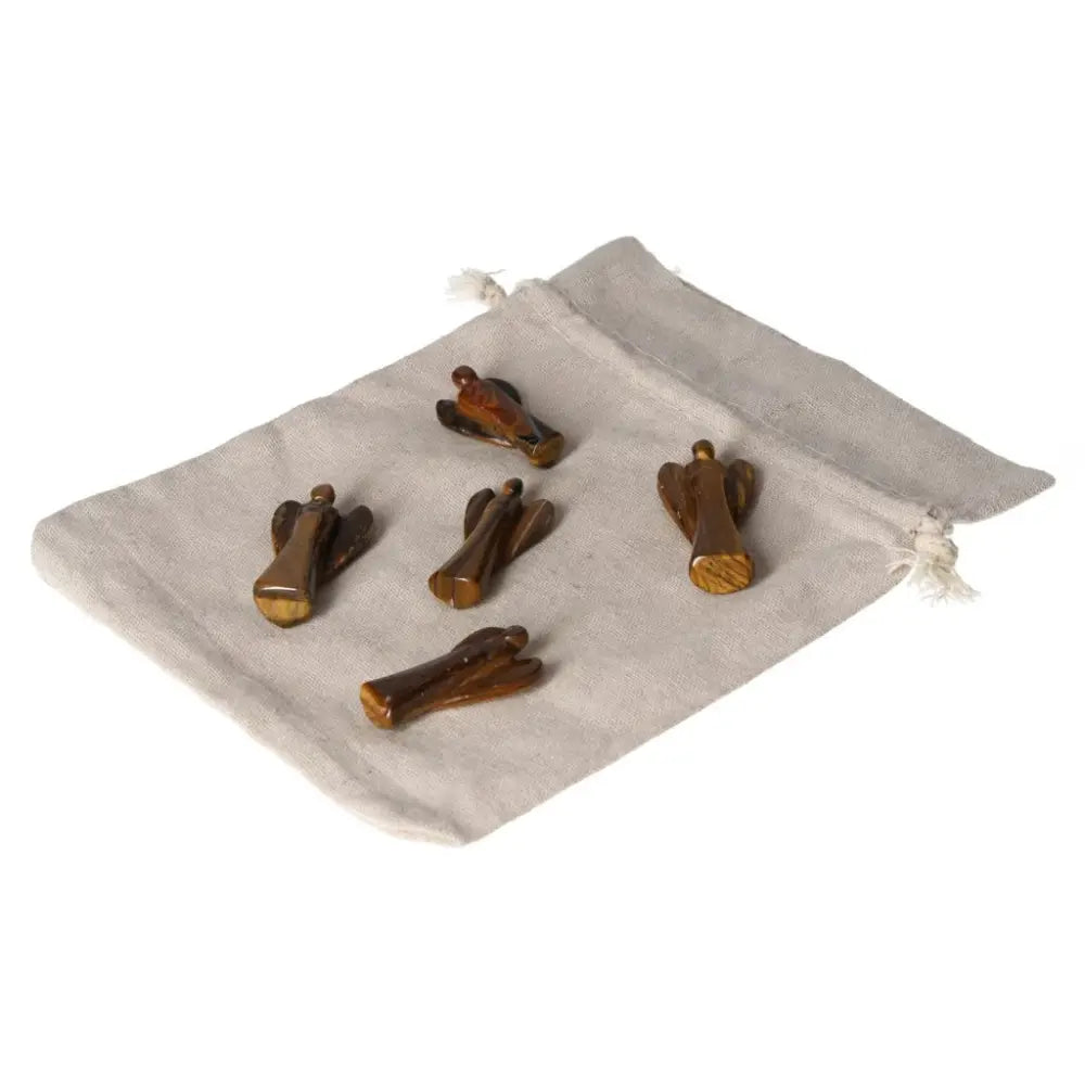 Small Tiger's Eye angel figurines on a cloth pouch, representing protection, strength, and spiritual guidance with a golden-brown shimmer.