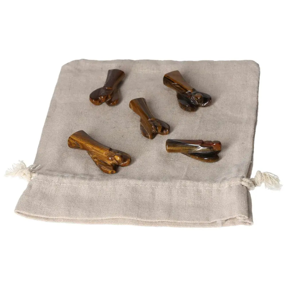 Five small Tiger's Eye angel figurines on a beige cloth pouch, symbolizing protection, strength, and divine guidance.