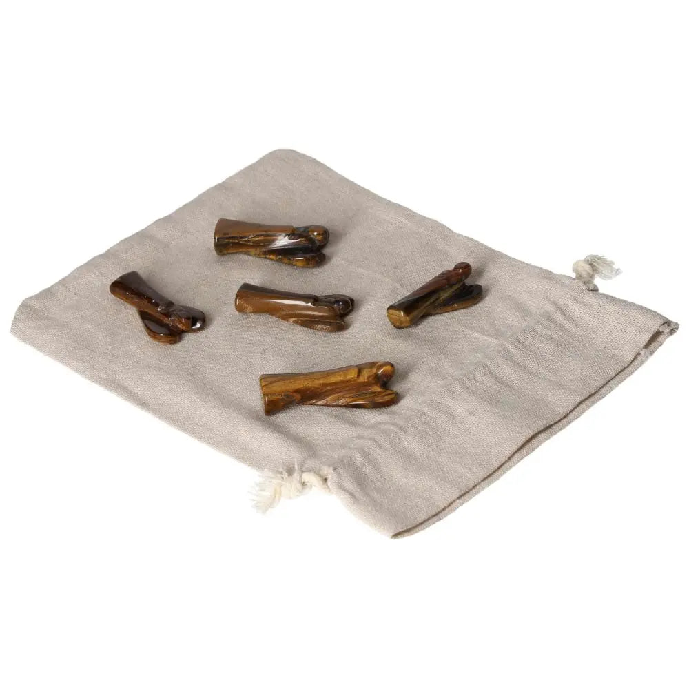 Five small Tiger's Eye angel figurines for protection and strength on a beige cloth bag.