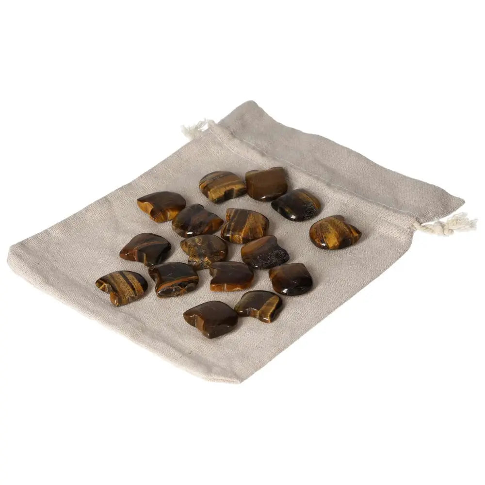 Tigers Eye small stones on a beige pouch, ideal for enhancing mental clarity, focus, and wealth management. Perfect for stability and joy.