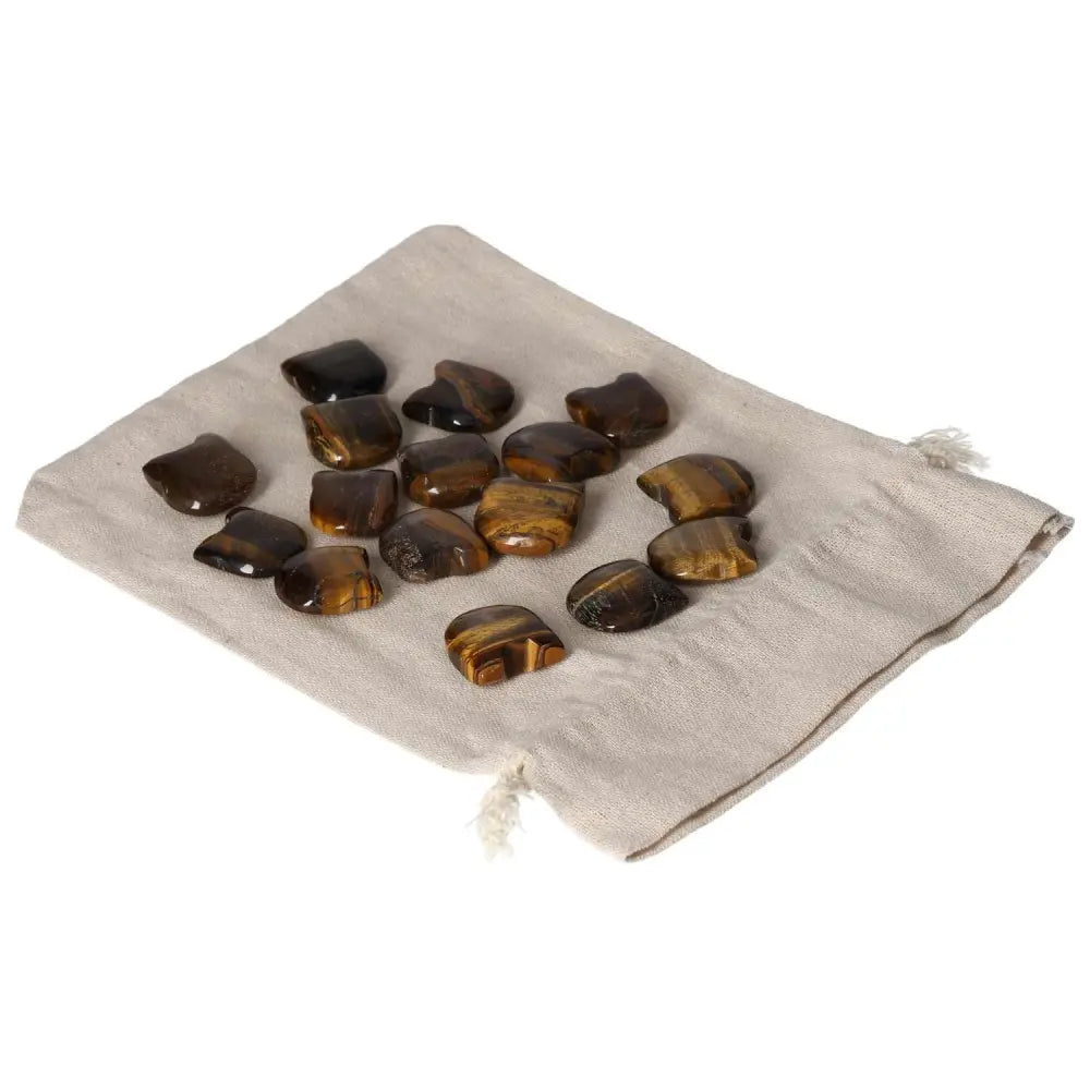 Tigers Eye small cat stones for mental clarity and focus, enhancing wealth management and providing stability, on a cloth pouch.