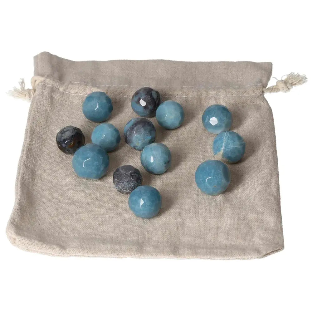 Collection of trolleite small geometric spheres on a beige cloth bag, showcasing rich blue colors for spiritual awareness and insight.