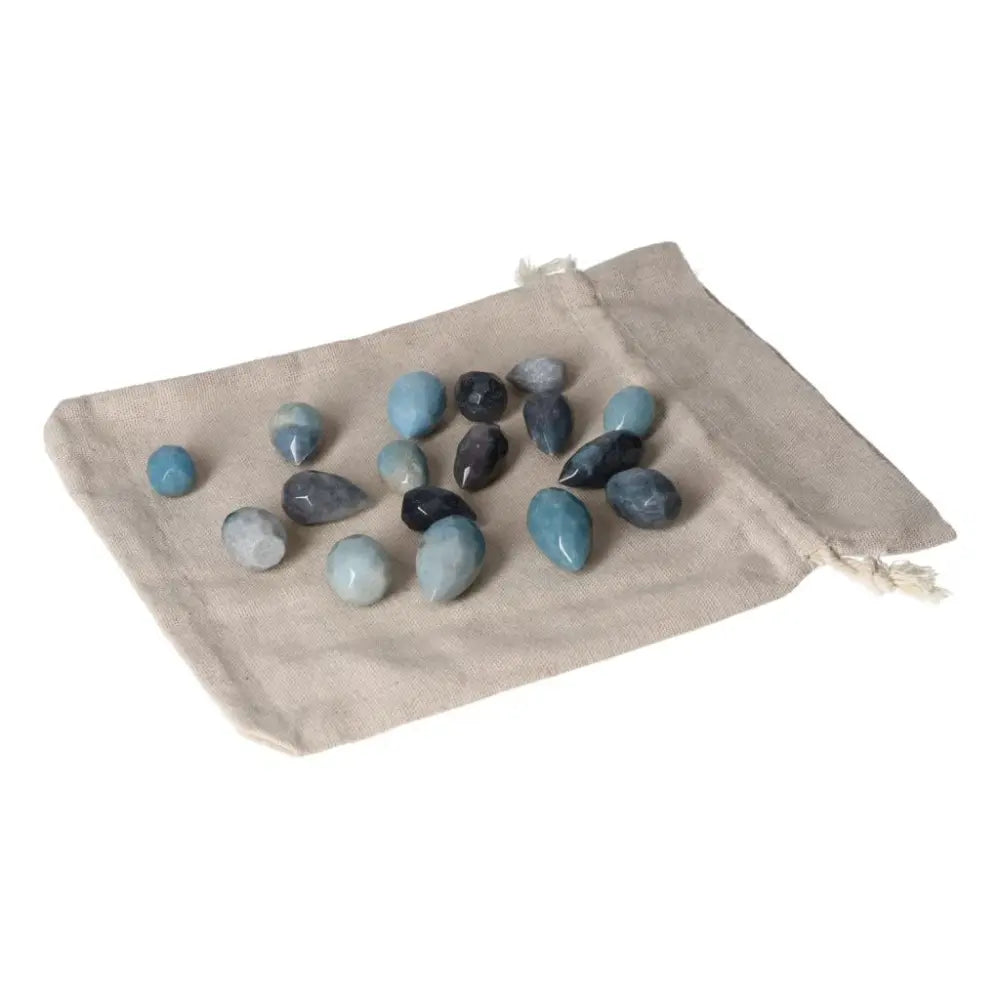 Trolleite small tear stones with rich blue-violet hues on a beige cloth bag, symbolizing spiritual insight and intuition.