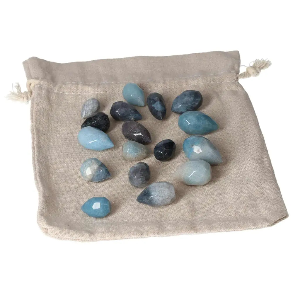 Trolleite Small Tear stones in varying blue hues on a beige cloth, symbolizing intuition, spiritual awareness, and emotional insight.