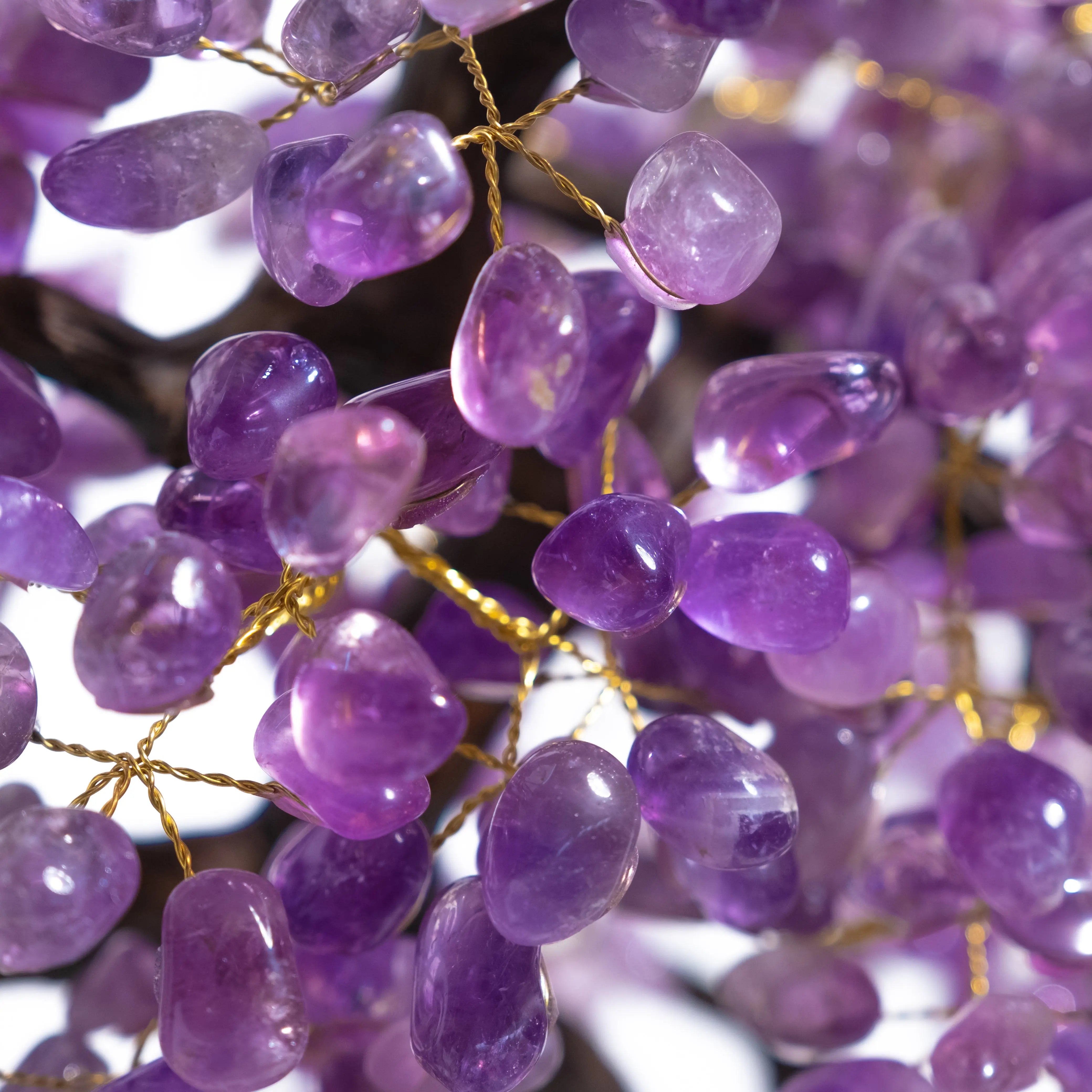 Close-up of a handcrafted amethyst crystal bonsai tree, showcasing genuine tumbled amethyst leaves radiating calming energy.