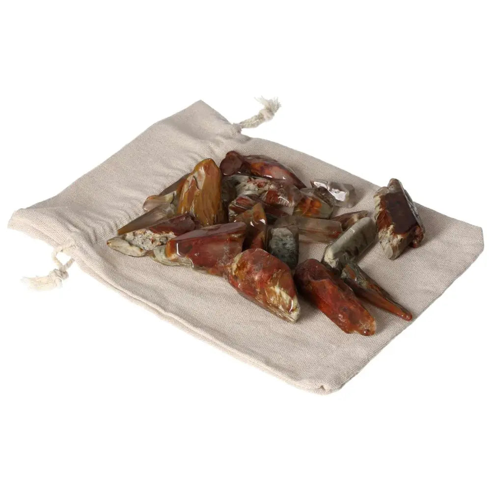 Tumbled Amphibole crystals elegantly displayed on a soft beige cloth, showcasing their natural beauty and spiritual allure.