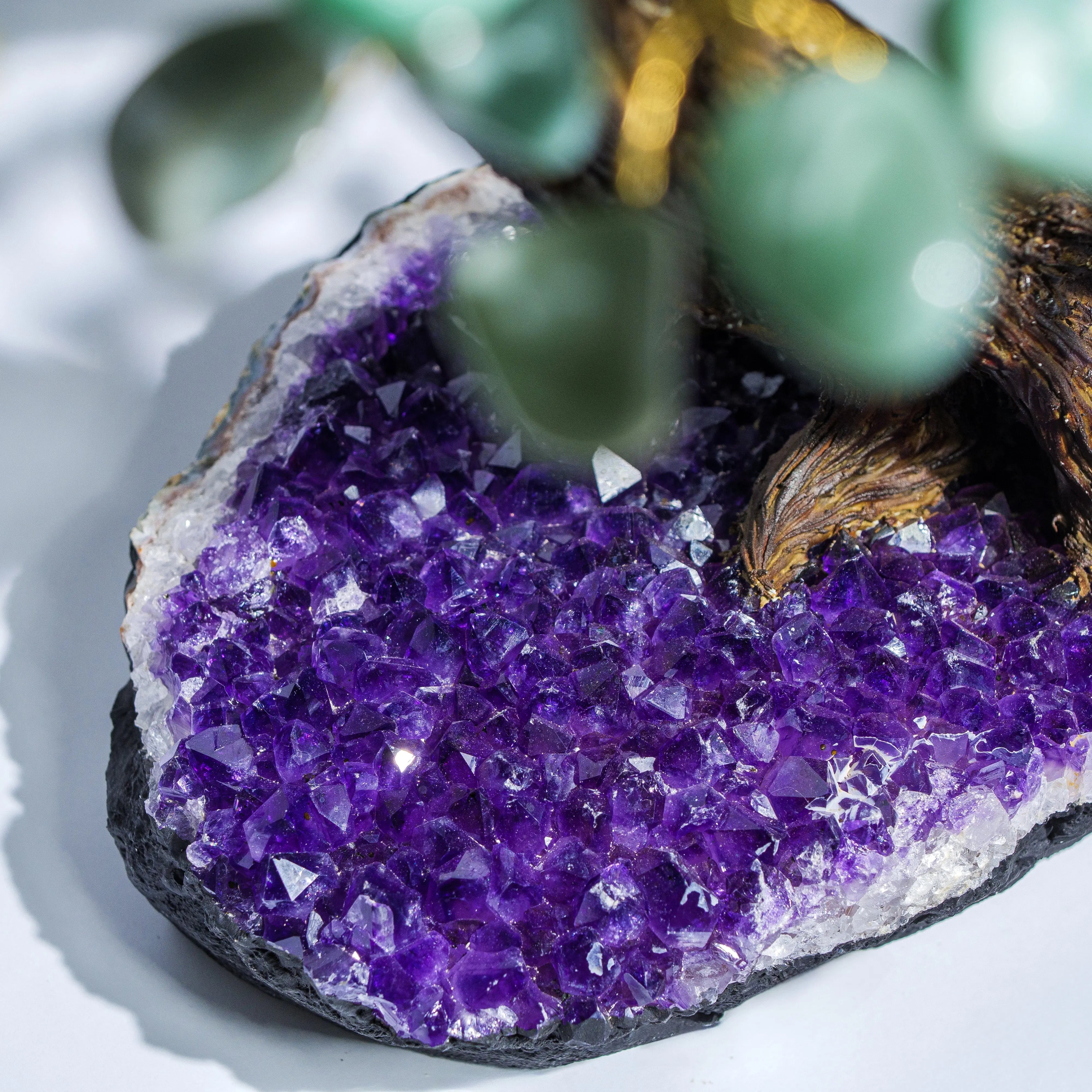 Close-up of a tumbled aventurine crystal bonsai tree with amethyst base, symbolizing prosperity and positive energy.