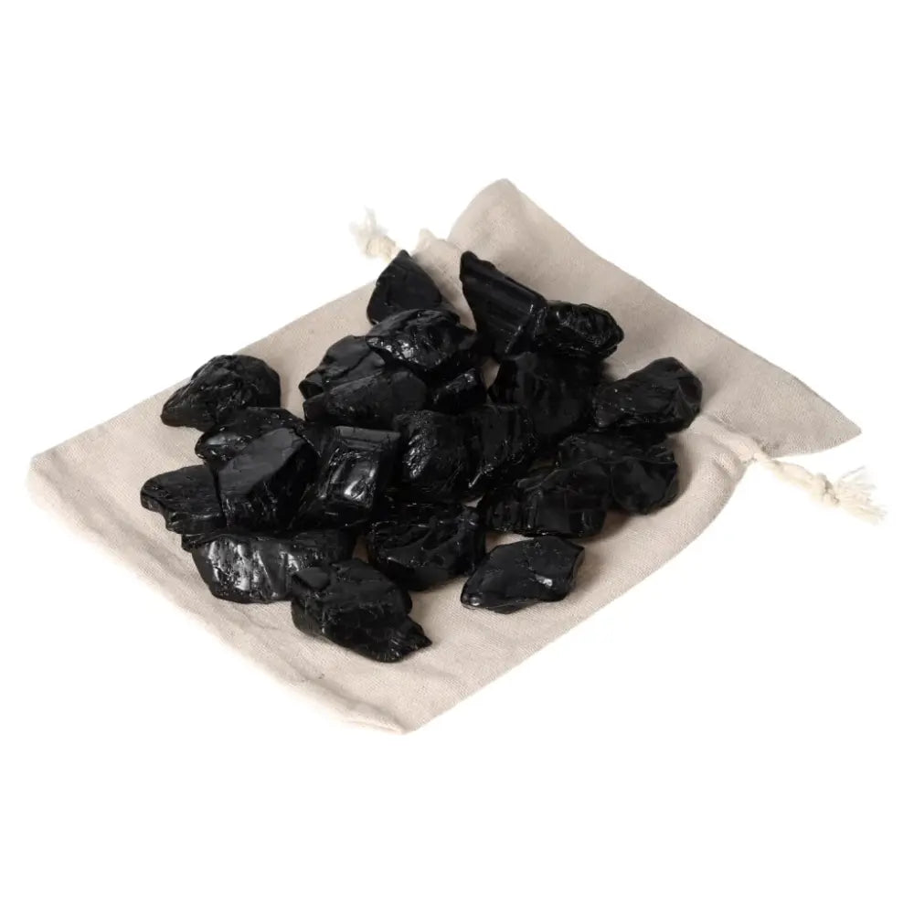 Tumbled Black Tourmaline stones on linen pouch, ideal for grounding and transforming negative energy, from Sylvia Crystals.
