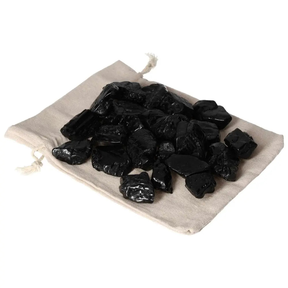 Tumbled Black Tourmaline L crystals on fabric pouch, providing grounding and mental clarity by dispelling negative energy, by Sylvia Crystals.