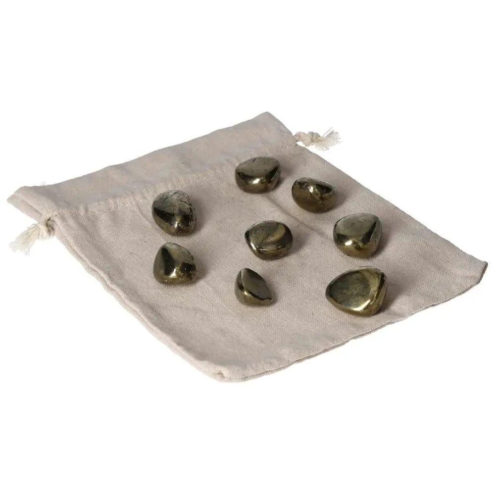 Tumbled Chalcopyrite crystals on a cloth pouch, offering healing benefits for stress, anxiety relief, and boosting self-confidence.