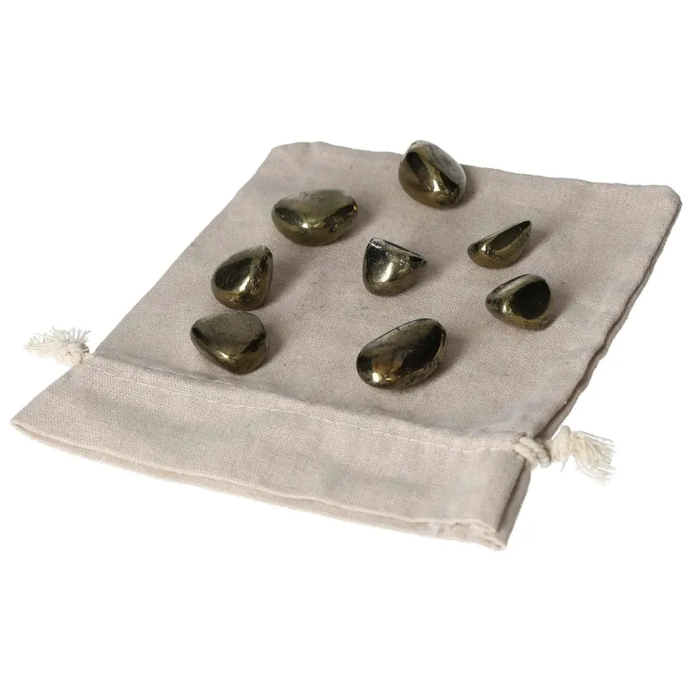 Tumbled Chalcopyrite crystals displayed on a cloth bag, known for stress relief, boosting self-confidence, and enhancing intuition.