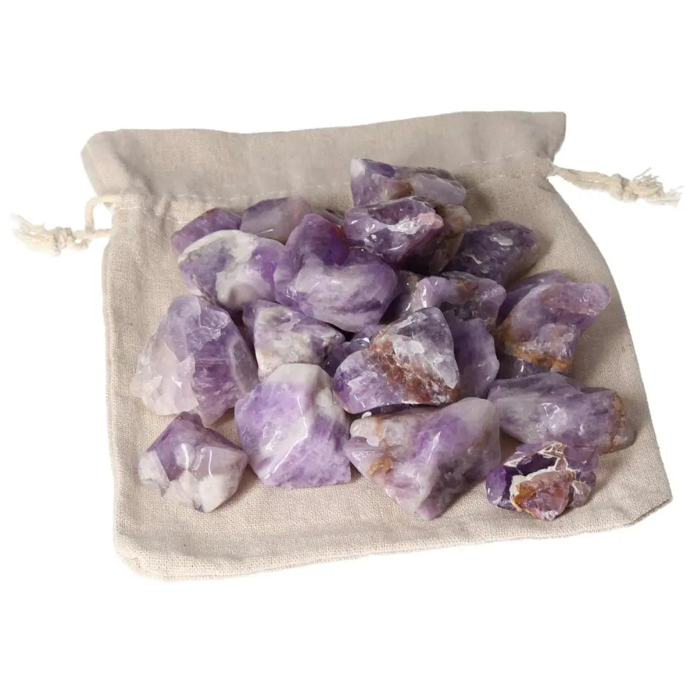 Tumbled Chevron Amethyst stones with deep purple and white bands on a cloth pouch, by Sylvia Crystals, showcasing premium quality.