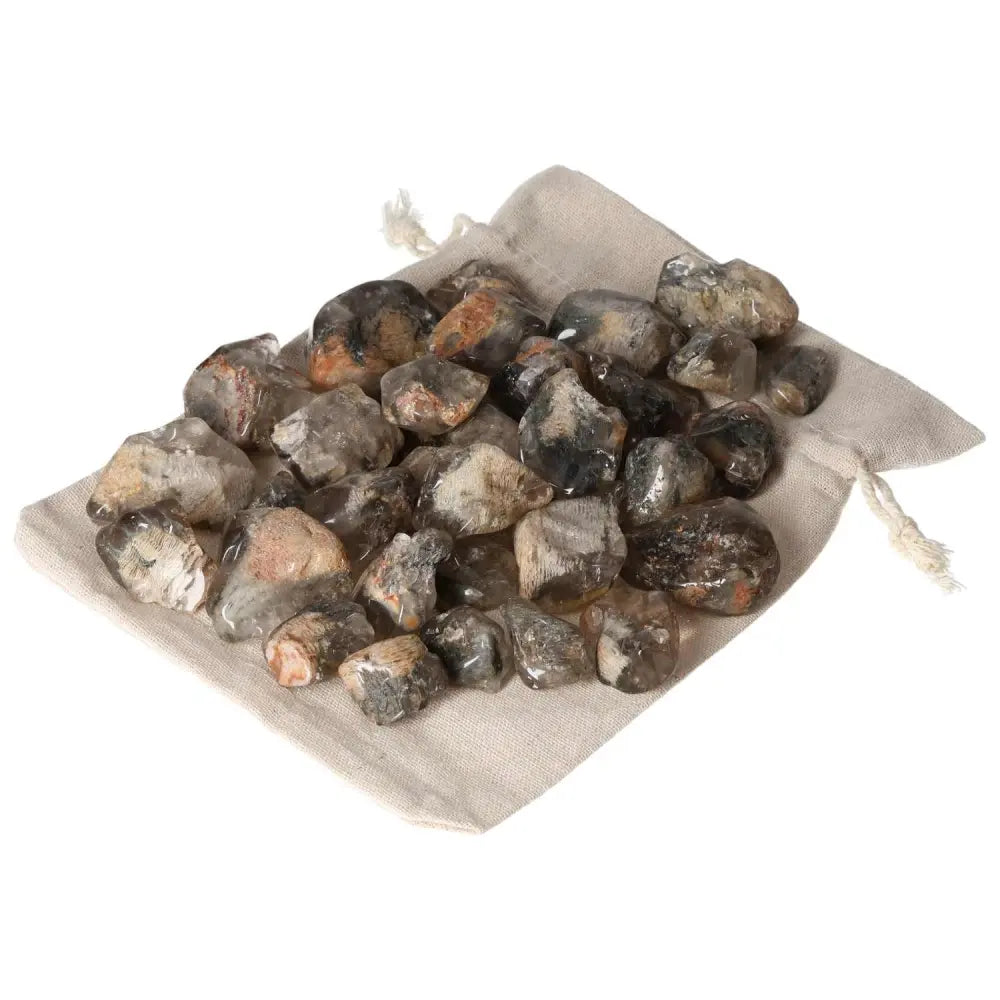 Premium Tumbled Lodolite gemstones from Sylvia Crystals on a fabric cloth, embodying elegance and mysticism for spiritual enhancement.