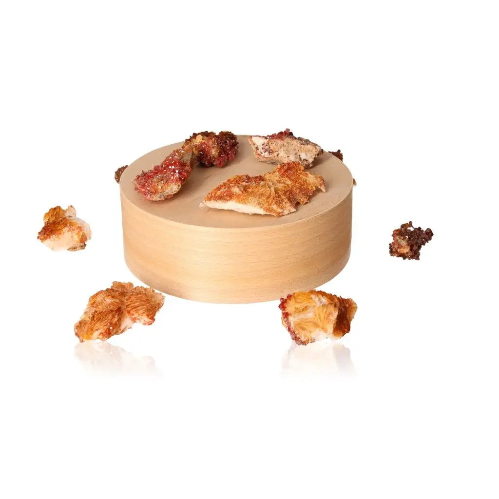 Vanadinite Druze crystals with vibrant red-orange hues displayed on a round wooden platform for grounding and creative focus.