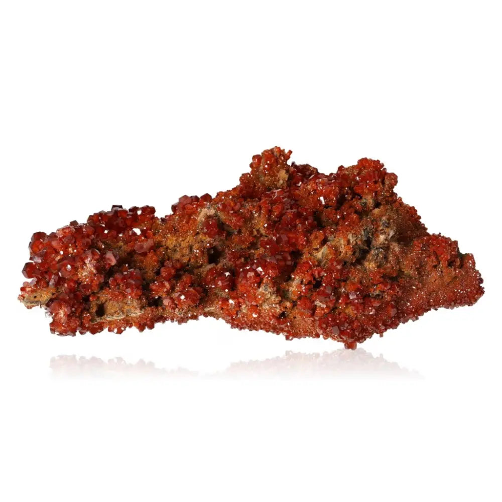 Vibrant red-orange Vanadinite Druze crystal, known for enhancing focus and creativity, showcasing unique formations and grounding properties.
