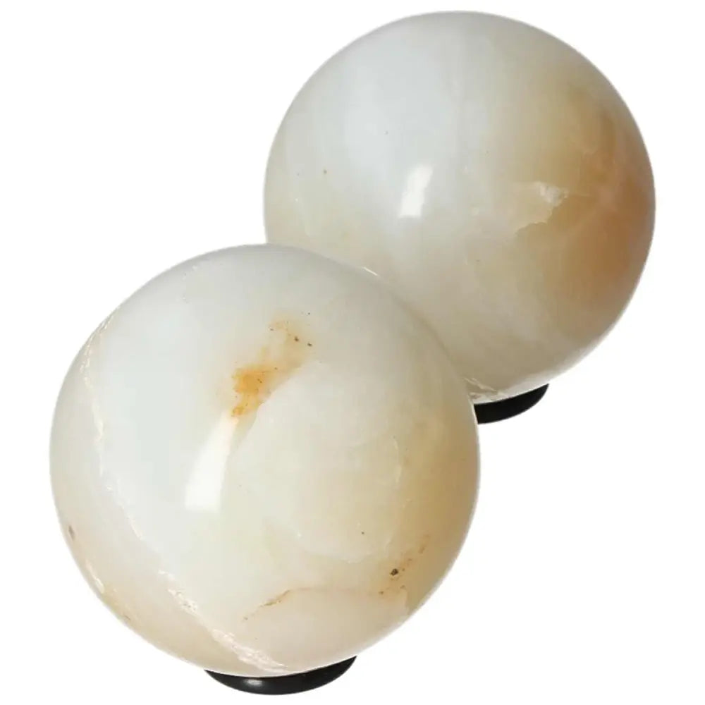 Pair of polished white onyx spheres for strength and self-discipline, promoting control and determination in challenging times.