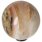 Polished white onyx sphere, symbolic of strength, determination, and self-discipline, with natural marbled patterns.