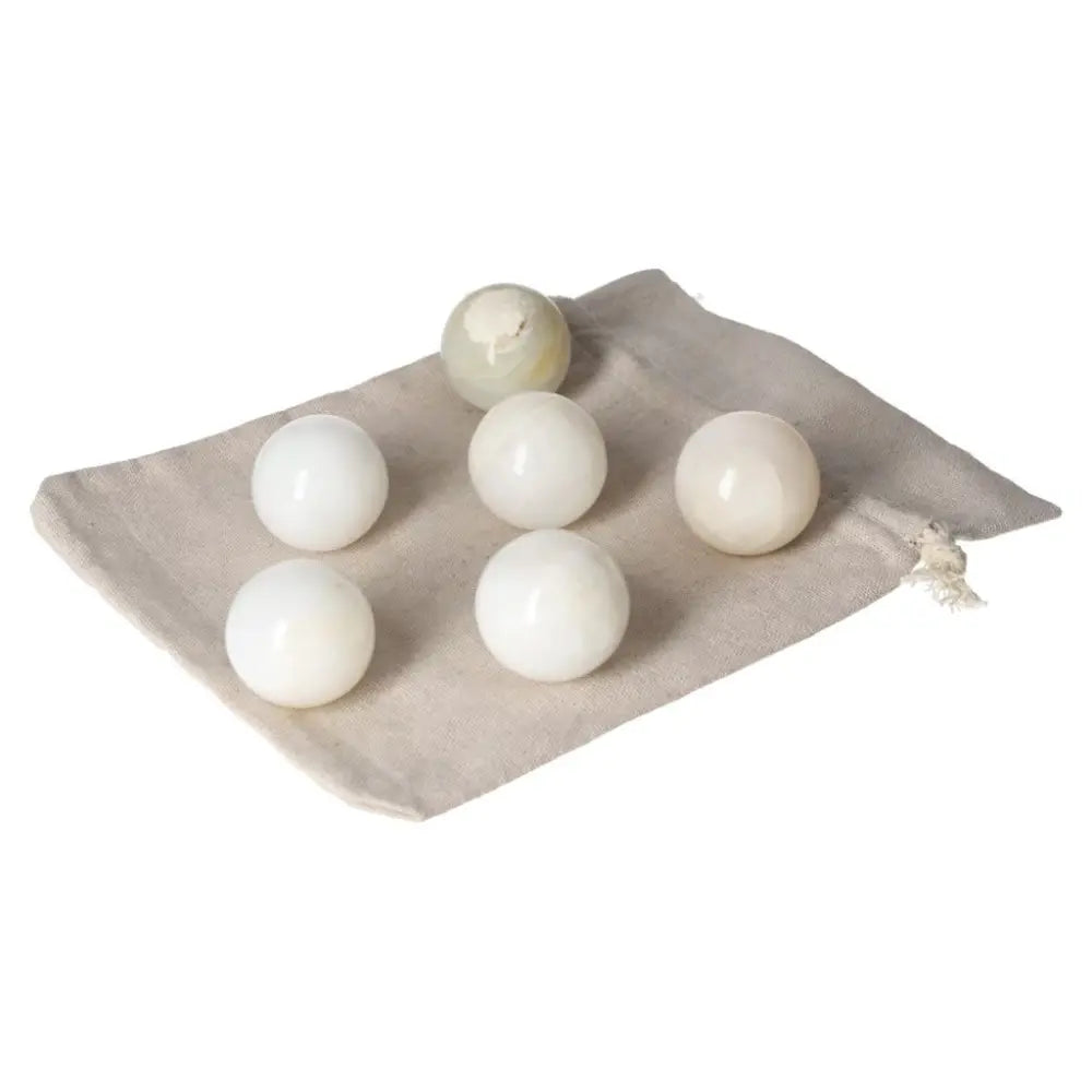 White Onyx Spheres on a cloth bag, symbolizing strength, control, and self-discipline, ideal for overcoming challenges.