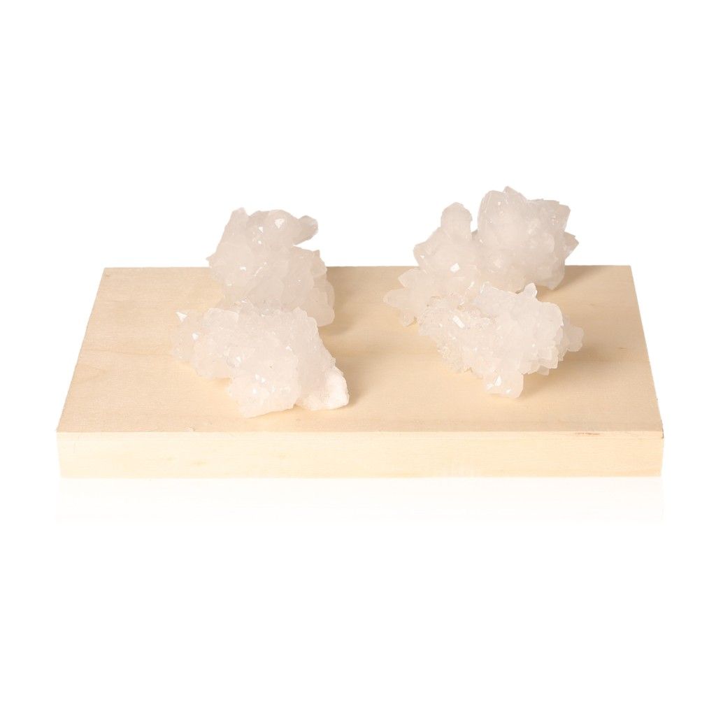 Four quartz druze crystals on a wooden platform, showcasing their natural beauty and unique energetic properties.