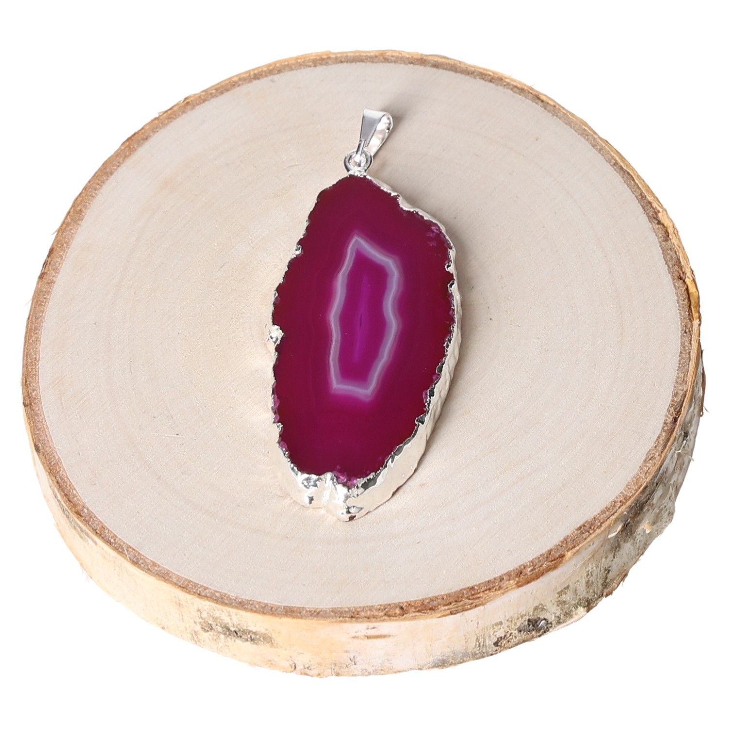 Agate pink slice metal pendant displayed on wooden surface, showcasing vibrant color and natural patterns.