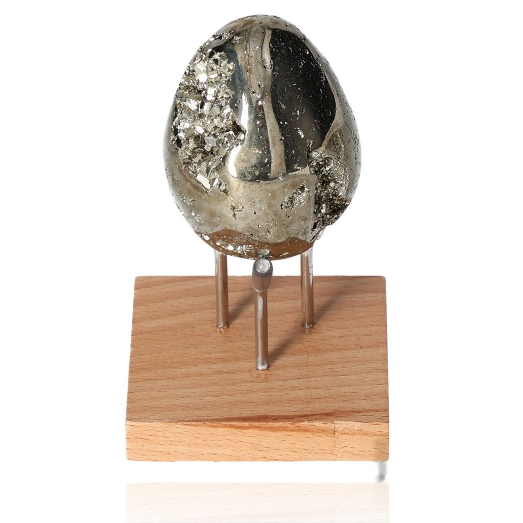 Pyrite egg displayed on a wooden stand, symbolizing courage and motivation, ideal for boosting independence and stimulating creativity.