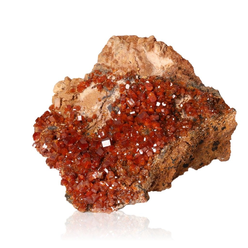 Vanadinite druze with vibrant reddish-brown hexagonal crystals on glassy surface, showcasing bold colors and geometric shapes.