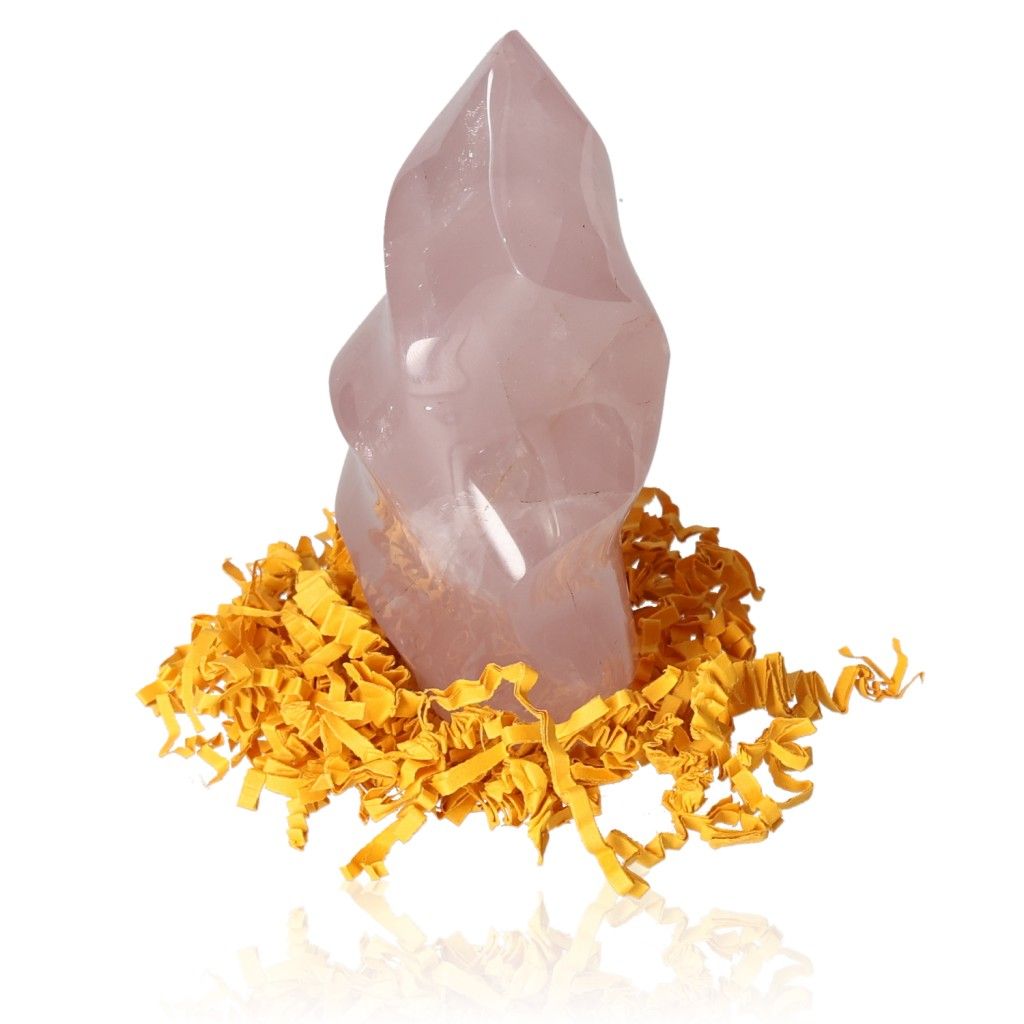 Rose Quartz Flame crystal surrounded by yellow shredded paper, offered by Sylvia Crystals for emotional healing and self-love.