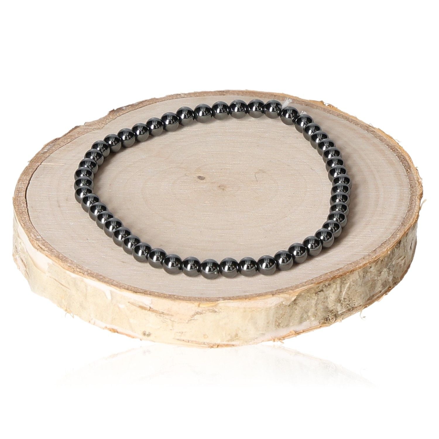 Hematite bracelet for men with 4mm beads displayed on a wooden slice.