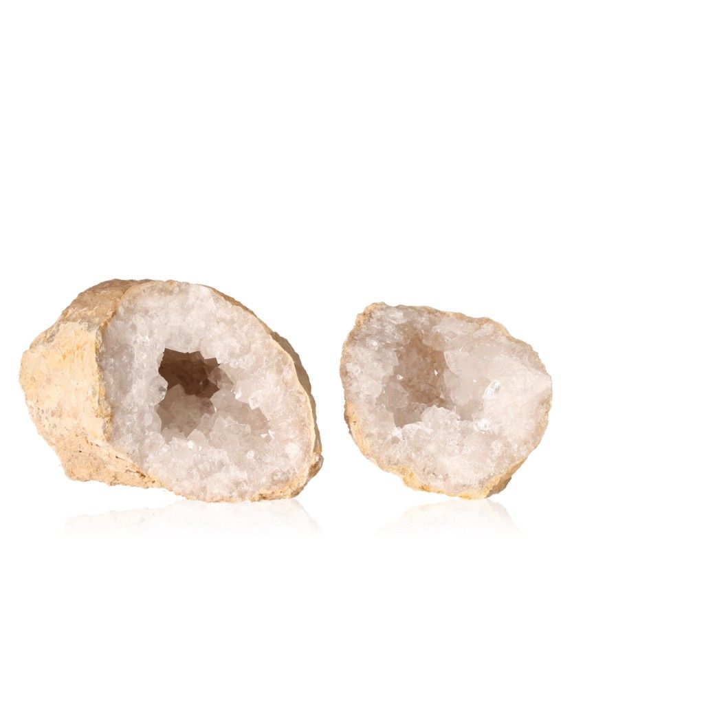 Milky quartz geodes with rough exteriors revealing sparkling white crystals, known for energy purification and balance, on a white background.