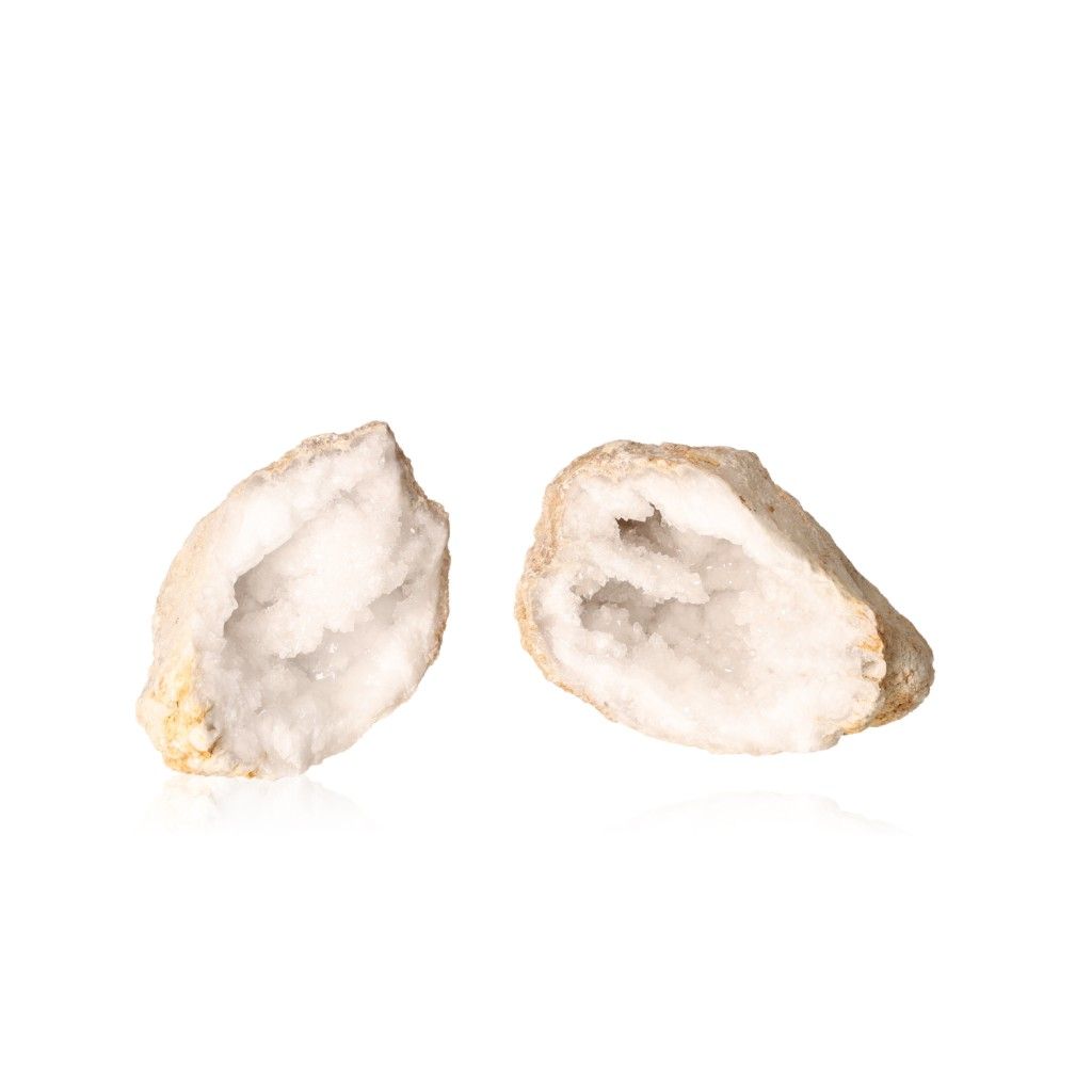 Two open milky quartz geodes displaying sparkling white crystals, known for purifying energy and enhancing tranquility and focus.