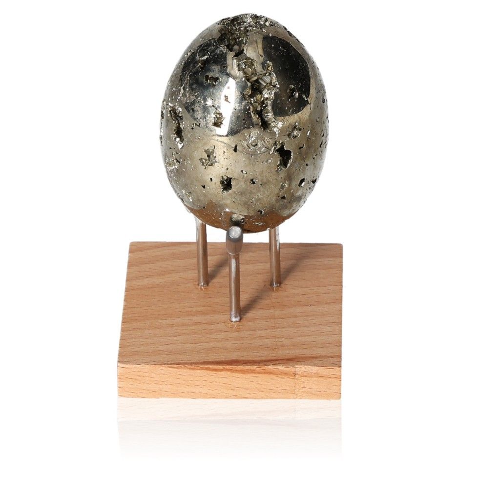 Pyrite egg on a wooden stand, symbolizing courage and motivation for personal development and goal achievement.