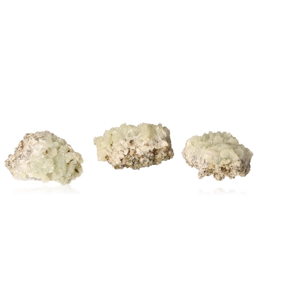 Small prehnite druze gemstones in translucent pale green, promoting calming energy and spiritual growth, displayed on a white background.