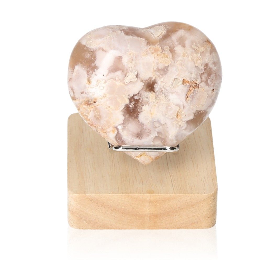 Heart-shaped flower agate stone on wooden stand, showcasing unique floral patterns for balance and tranquility.