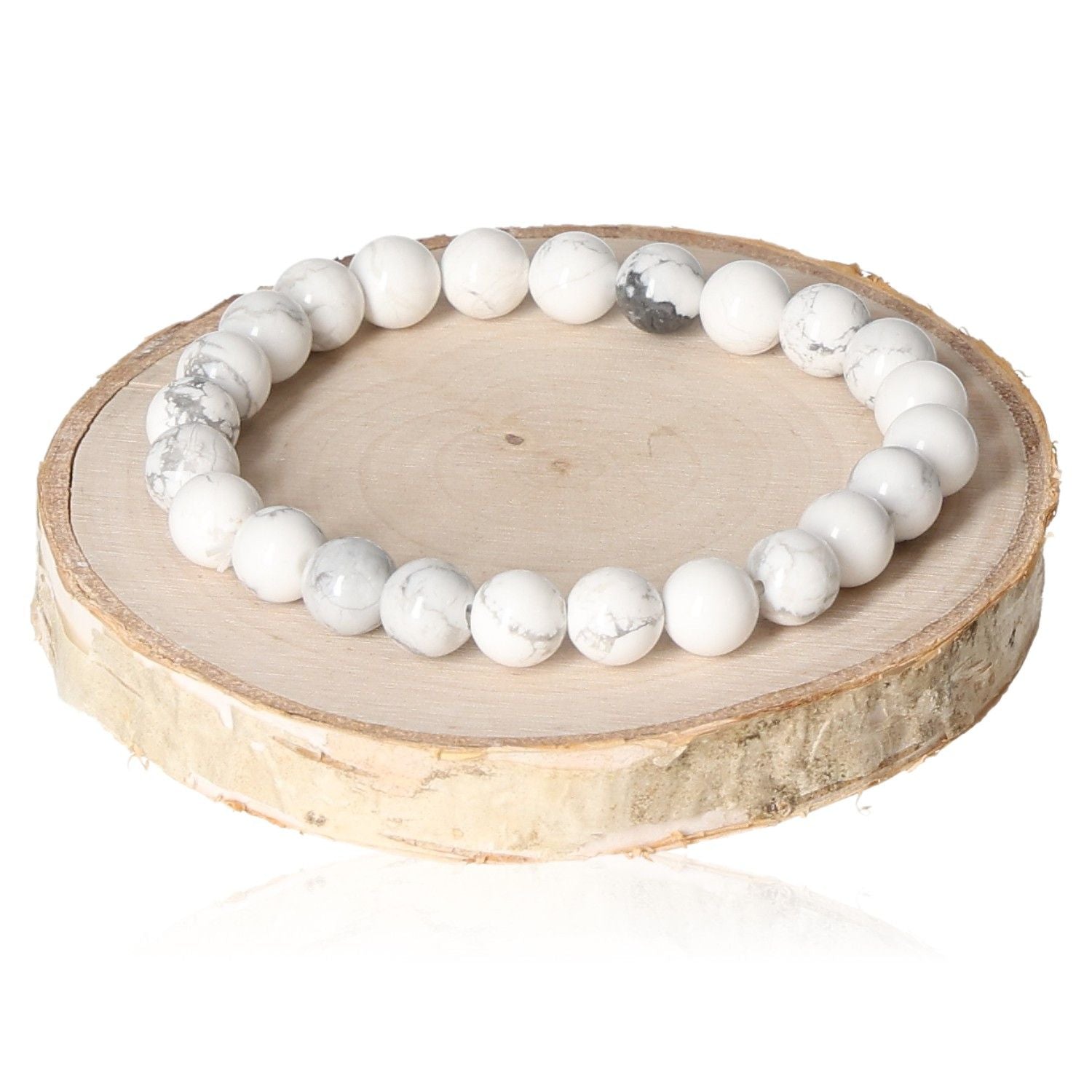 White magnezite bracelet with 8mm beads displayed on a wooden slice, highlighting its natural stone texture and elegance.