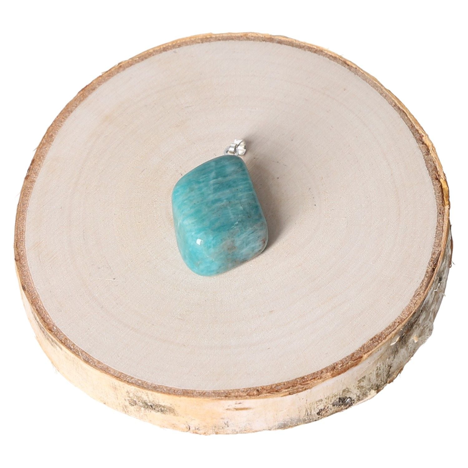 Amazonite AA tumbled pendant on wooden slice, showcasing its polished turquoise blue surface for jewelry enthusiasts.