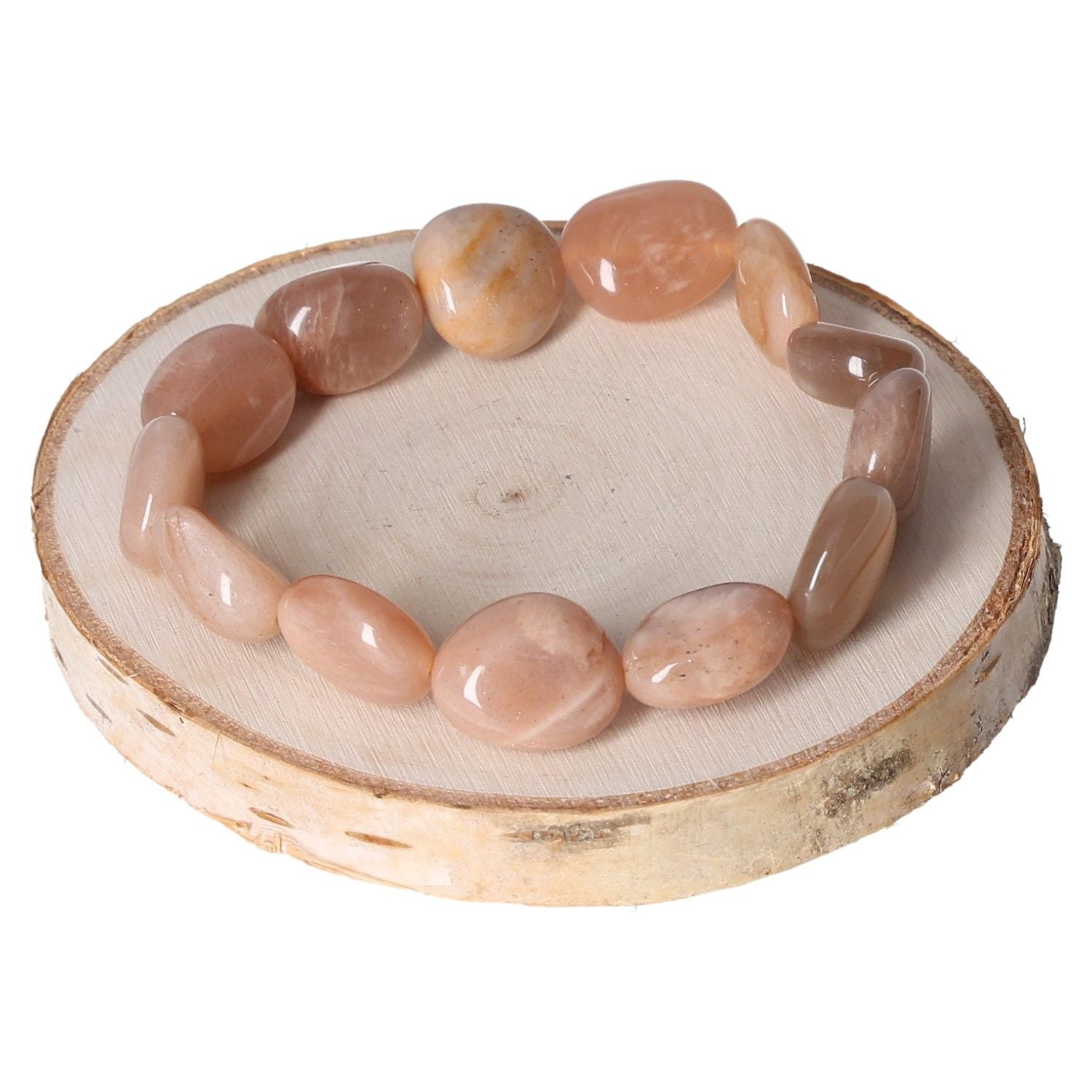 Tumbled moonstone bracelet on wooden slice, featuring polished stones for natural healing and elegance.